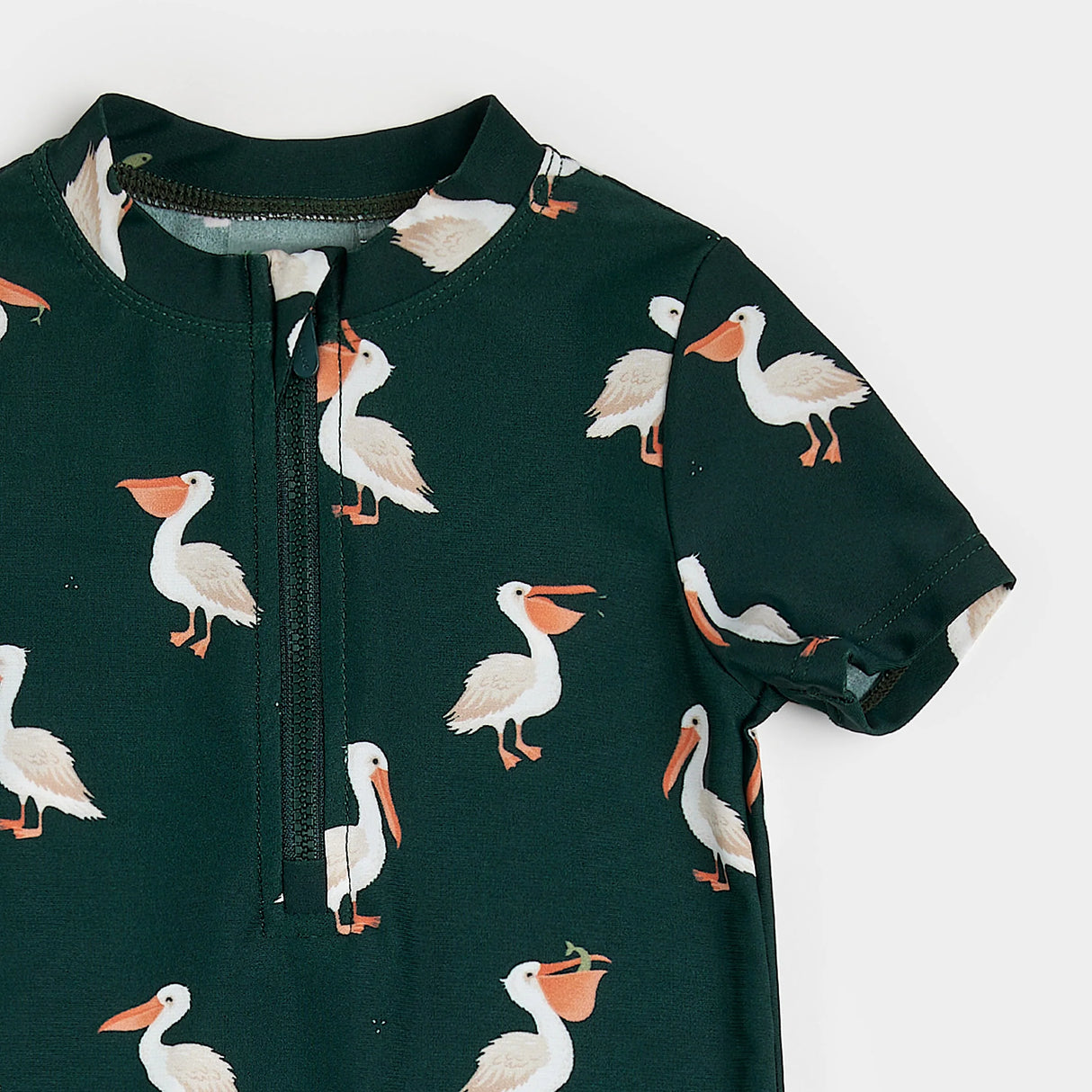 Close-up view of pelican print on deep sky blue recycled fabric of infant swim romper.