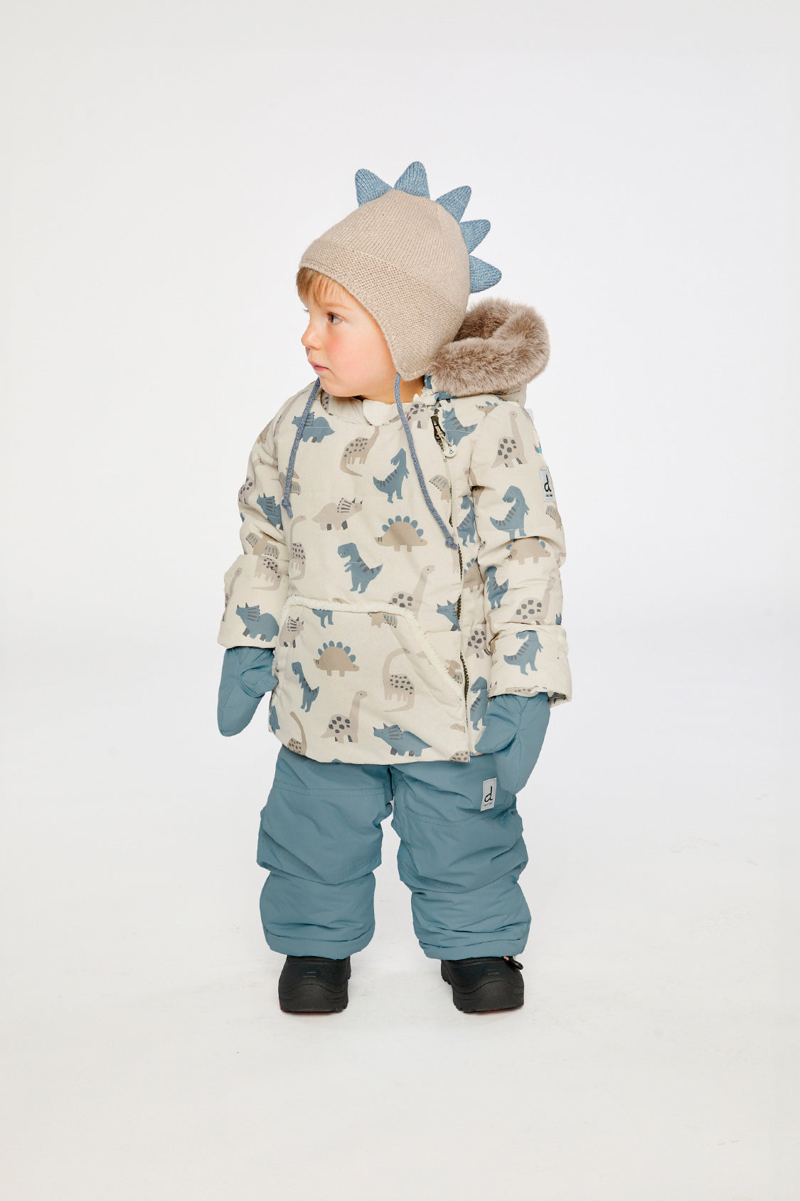 Baby wearing the Deux par Deux baby two-piece snowsuit in Blue Dinosaur Print in a winter lookbook view