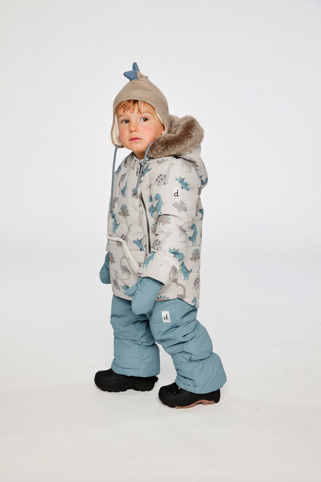 Deux par Deux baby two-piece snowsuit in Blue Dinosaur Print shown from an alternate modeled winter angle