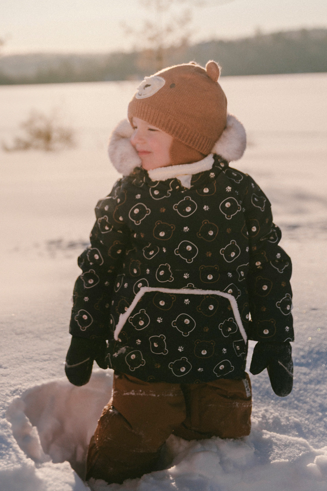 Baby wearing the Deux par Deux baby two-piece snowsuit in Blue Printed Teddy Bears during outdoor winter play