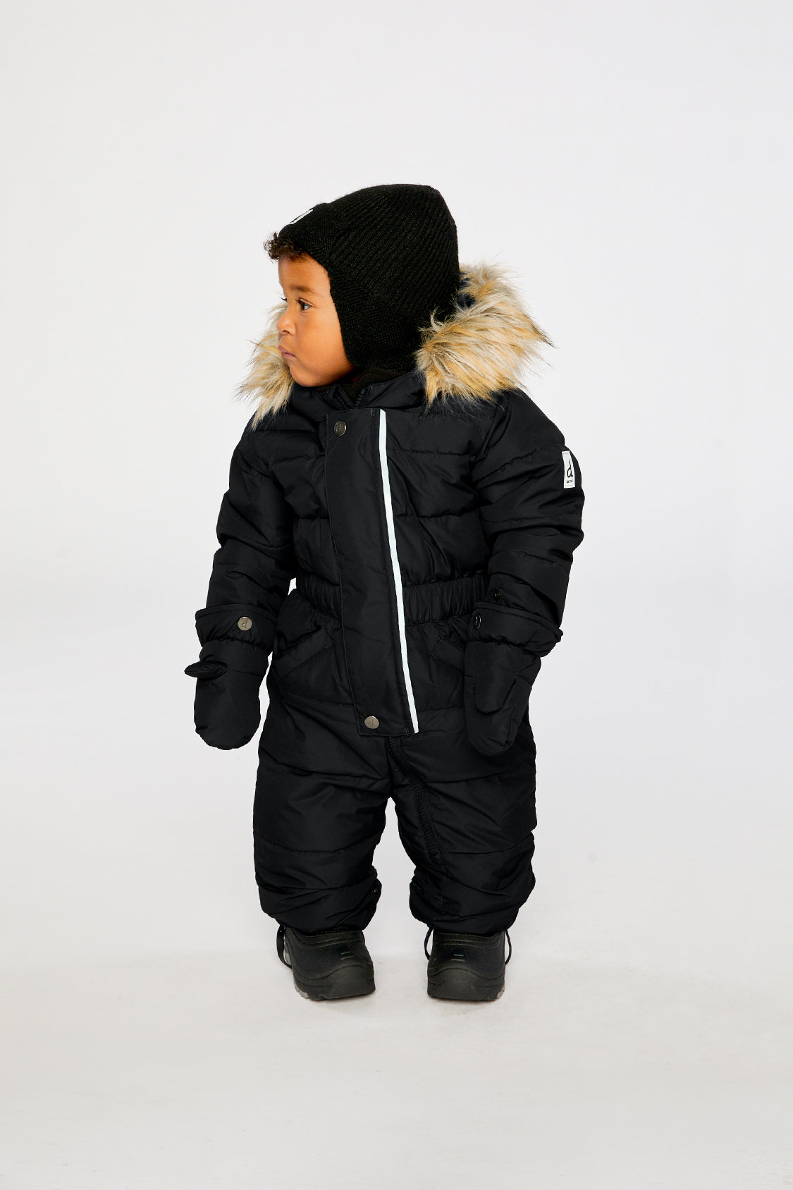 Baby wearing the Deux par Deux Baby Original puffy one-piece snowsuit in Black in a winter lookbook view