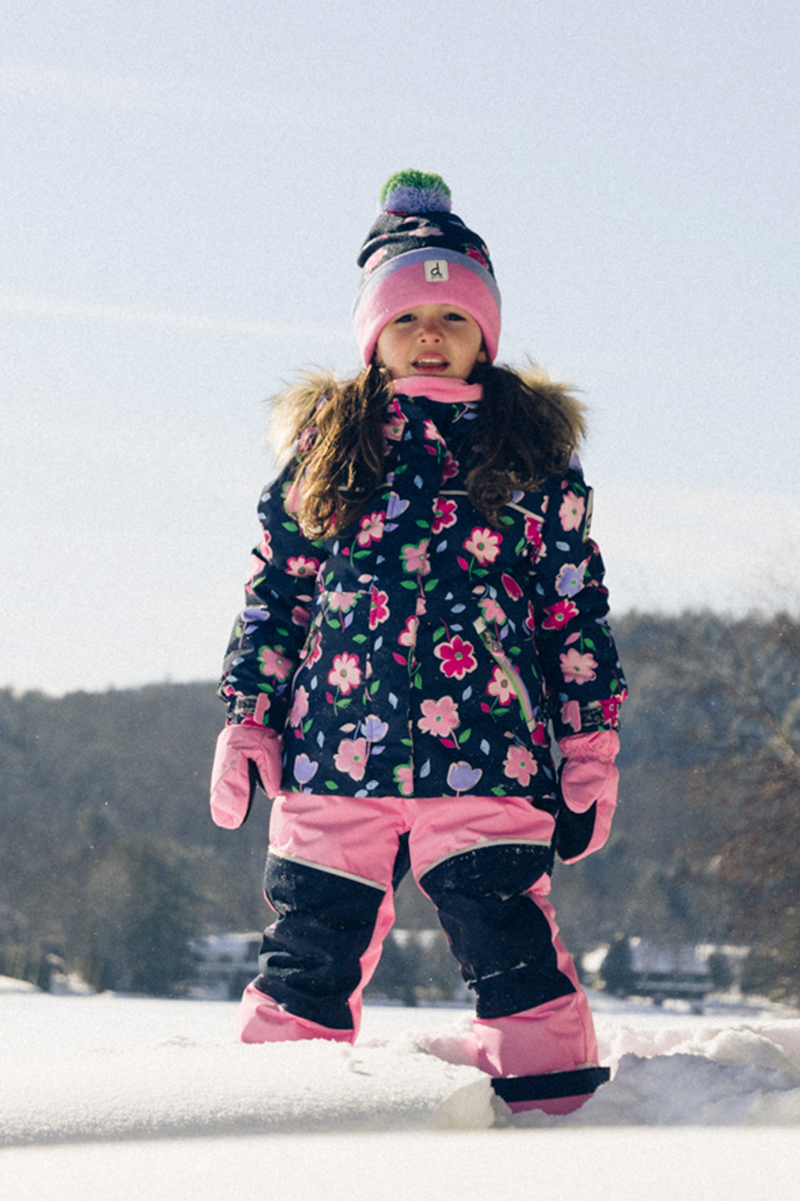Girl wearing Deux par Deux blue floral DISCOVER snowsuit for winter snow play