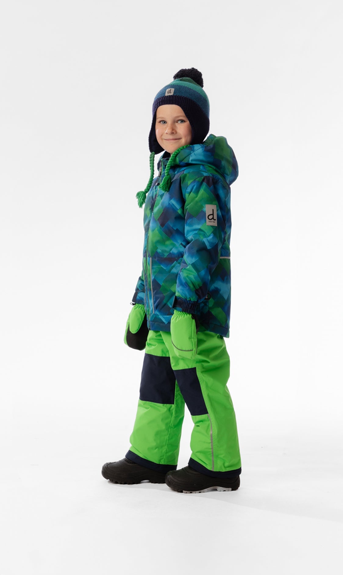 Side view of a child wearing the blue and green checkered snowsuit with green pants and navy knee panels