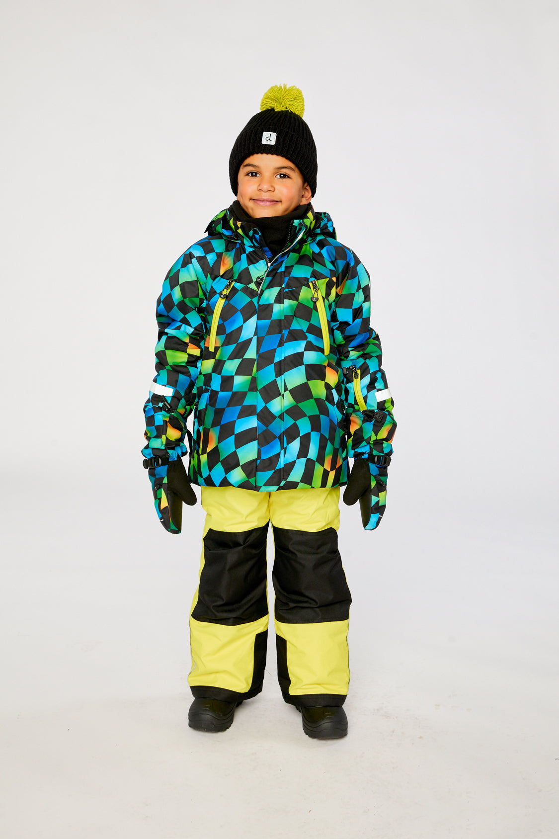 Child wearing the Deux par Deux PLAY two-piece snowsuit in Green Yellow and Blue Checkerboard with Yellow Pants in a winter lookbook view