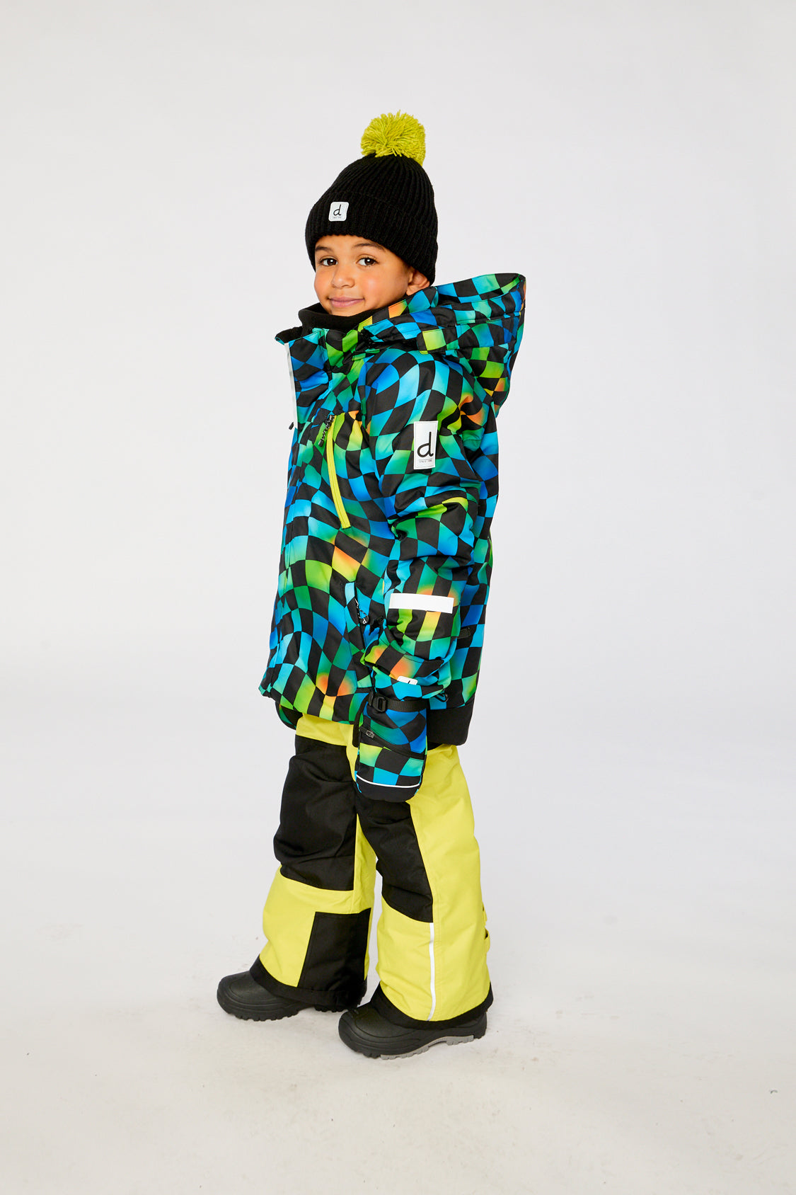 Deux par Deux PLAY two-piece snowsuit in Green Yellow and Blue Checkerboard with Yellow Pants shown from an alternate modeled winter angle