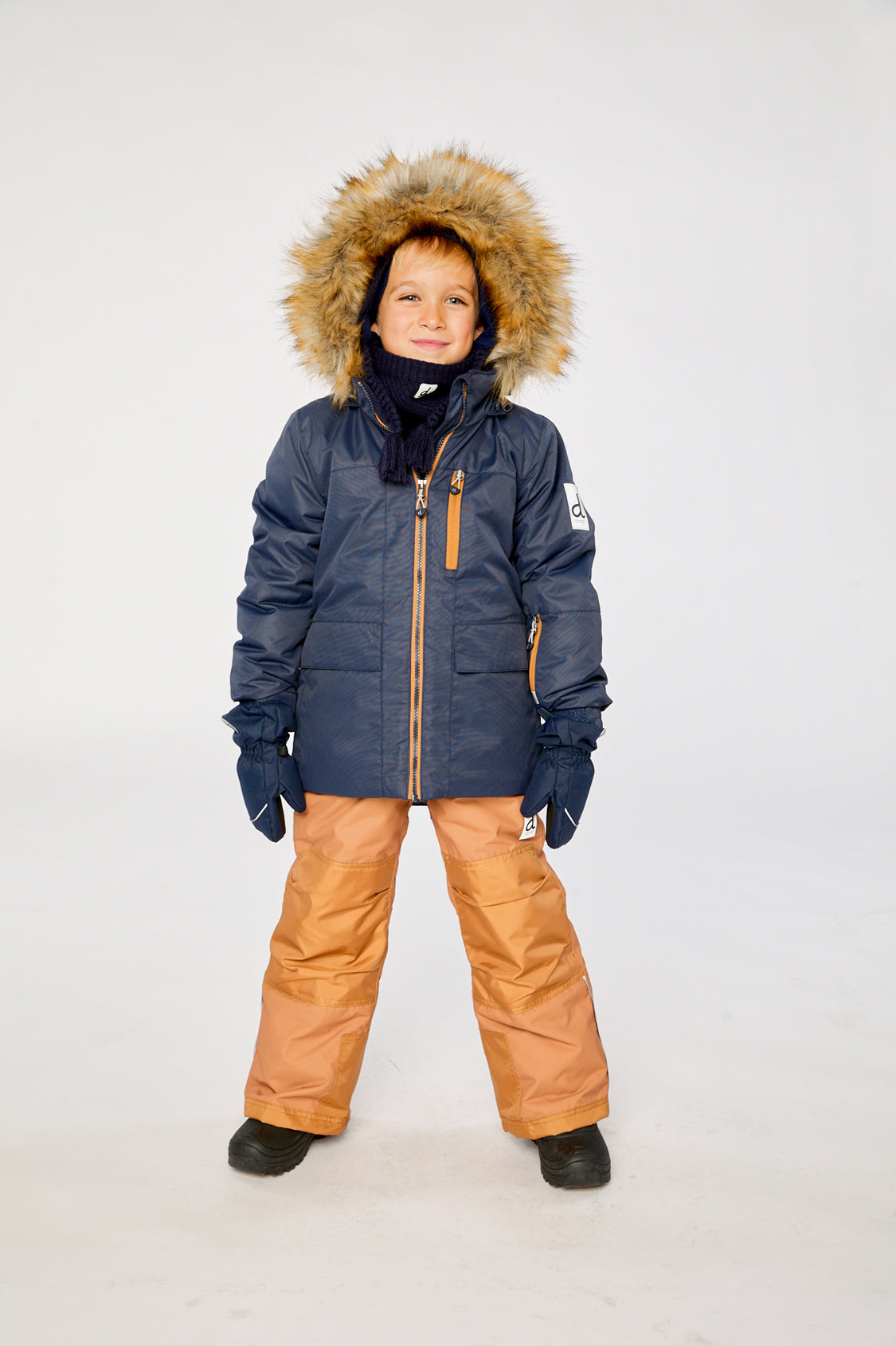 Deux par Deux PLAY two-piece snowsuit in Navy Blue with Brown Pants shown from an alternate modeled winter angle