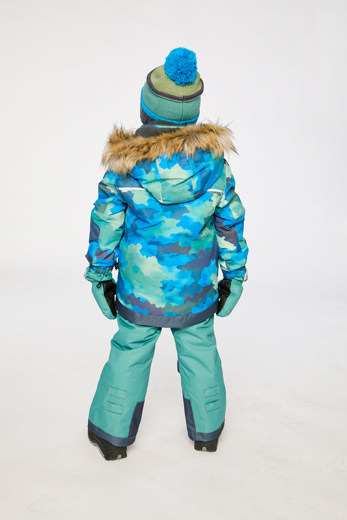 Boy in Deux par Deux -30°C blue camo snowsuit for skiing sledding and snow play