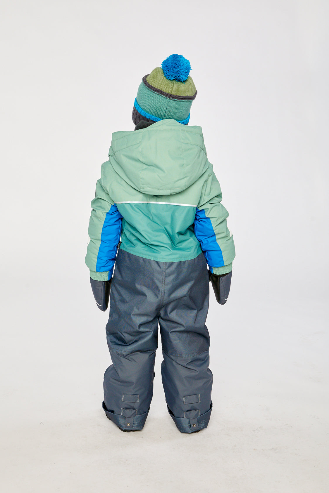 Kids PLAY one-piece snowsuit in sage green and grey shown in an alternate winter lookbook view