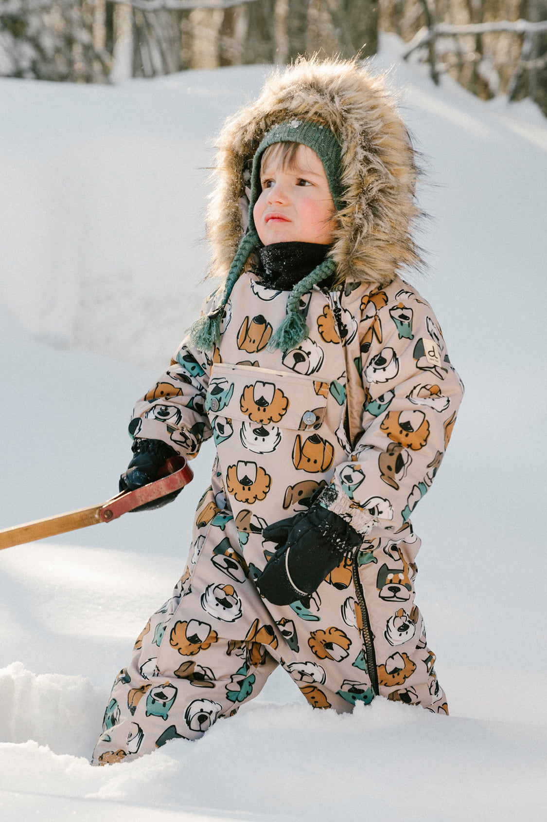 Baby boy wearing Deux par Deux beige dog print one-piece winter snowsuit