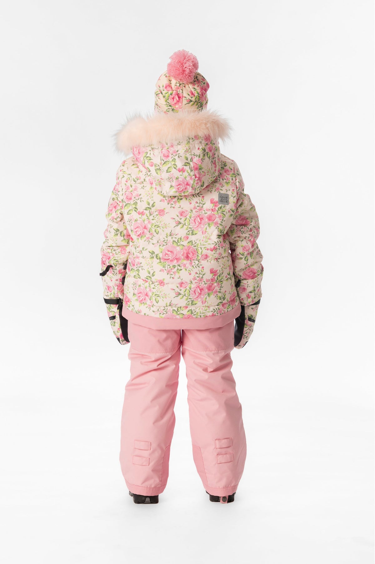 Back view of a girl in the pink mini flower Deux par Deux PLAY snowsuit