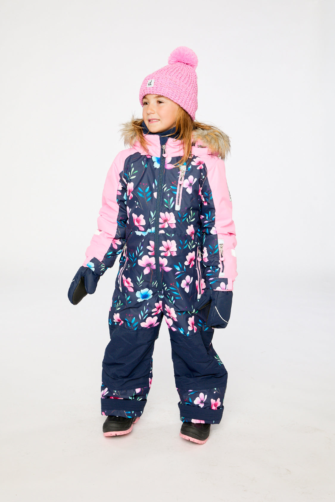 Girl wearing Deux par Deux blue floral one-piece PLAY snowsuit for winter snow play