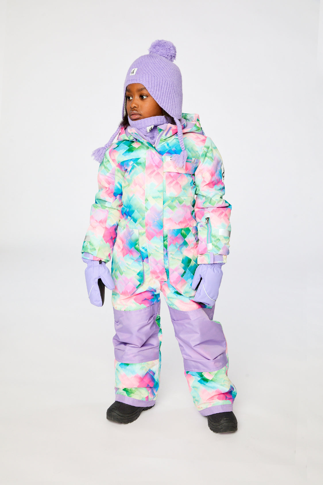 Child wearing the Deux par Deux multicolor diamond-print PLAY one-piece snowsuit in a winter lookbook view