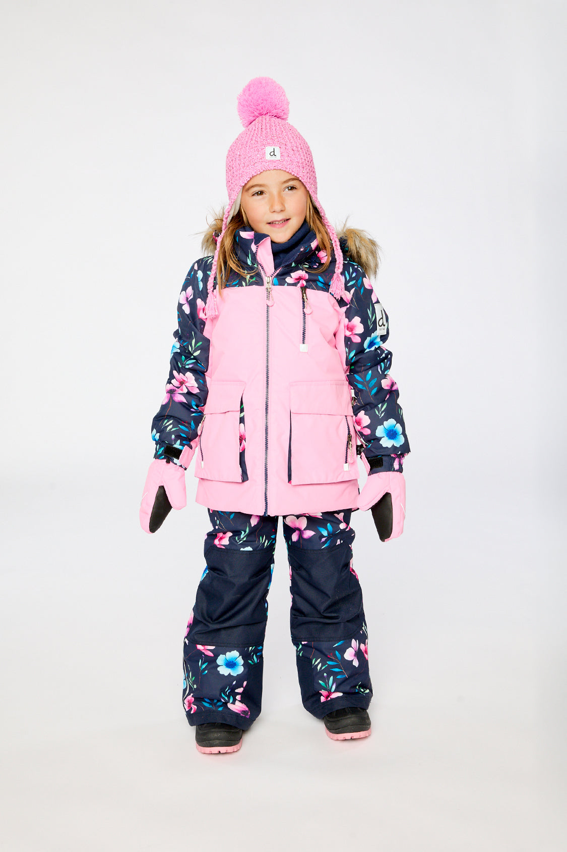 Girl wearing Deux par Deux pink PLAY snowsuit with floral jacket panels and snow pants