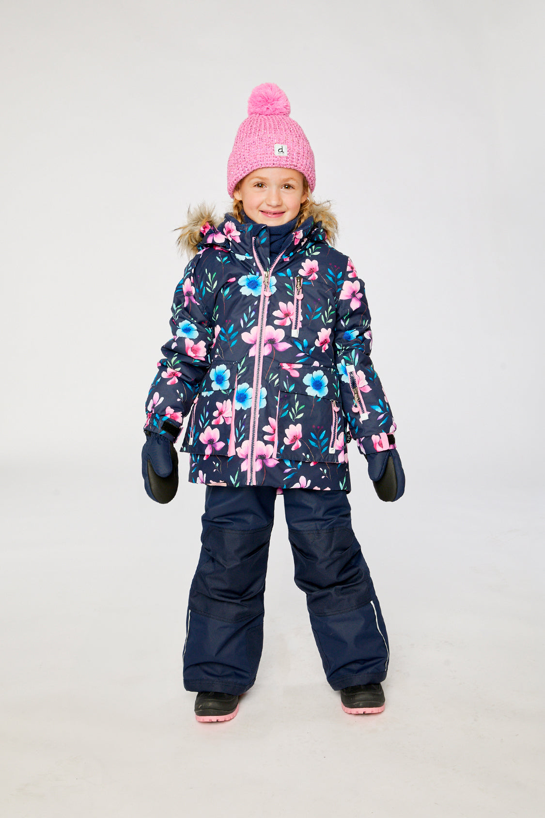 Child wearing the Deux par Deux PLAY two-piece snowsuit in Blue Floral Print in a winter lookbook view