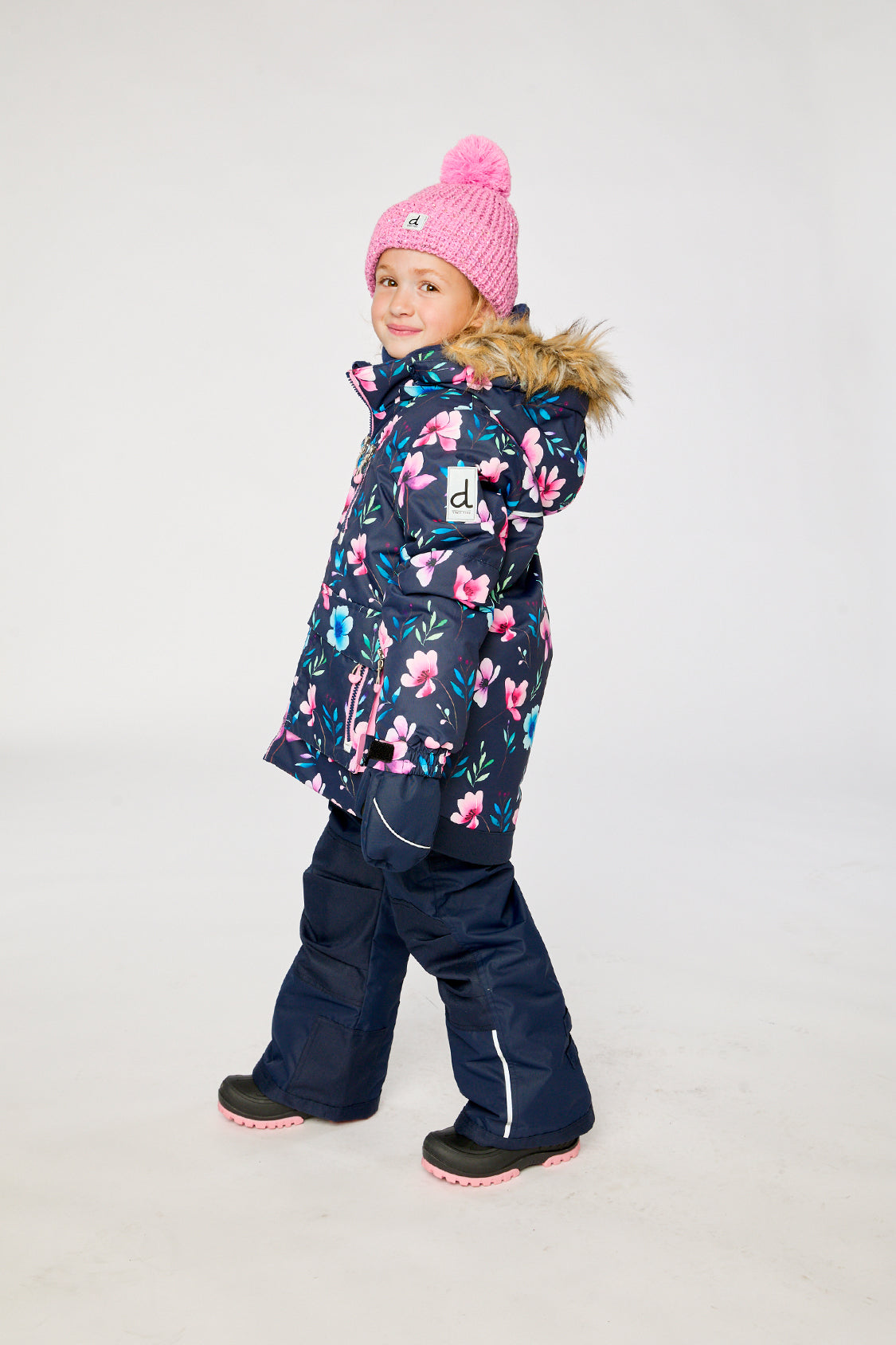 Deux par Deux PLAY two-piece snowsuit in Blue Floral Print shown from an alternate modeled winter angle
