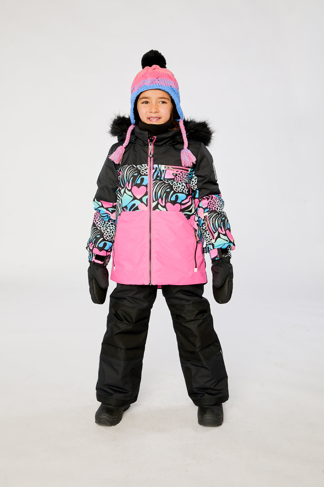 Girl wearing Deux par Deux black zebra PLAY snowsuit with pink colorblock jacket