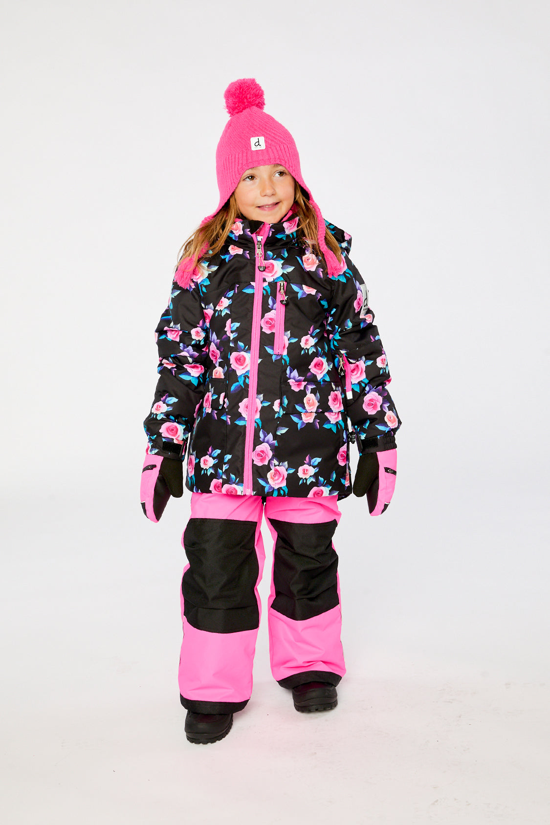 Girl wearing Deux par Deux black rose PLAY snowsuit with bright pink snow pants