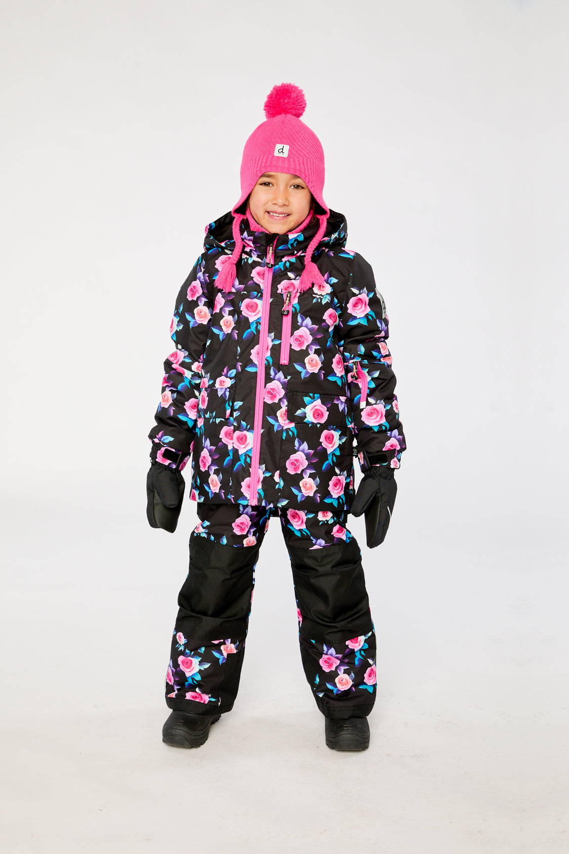 Girl wearing Deux par Deux coordinated black rose PLAY snowsuit for winter snow play
