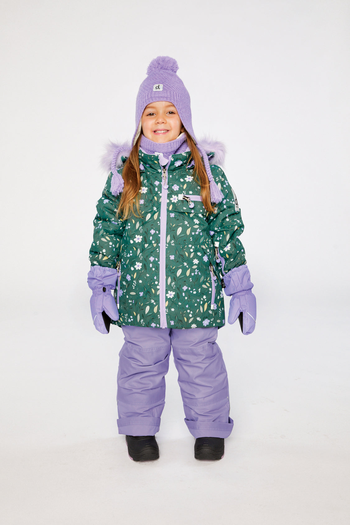 Girl wearing Deux par Deux green mini flower PLAY snowsuit with purple snow pants