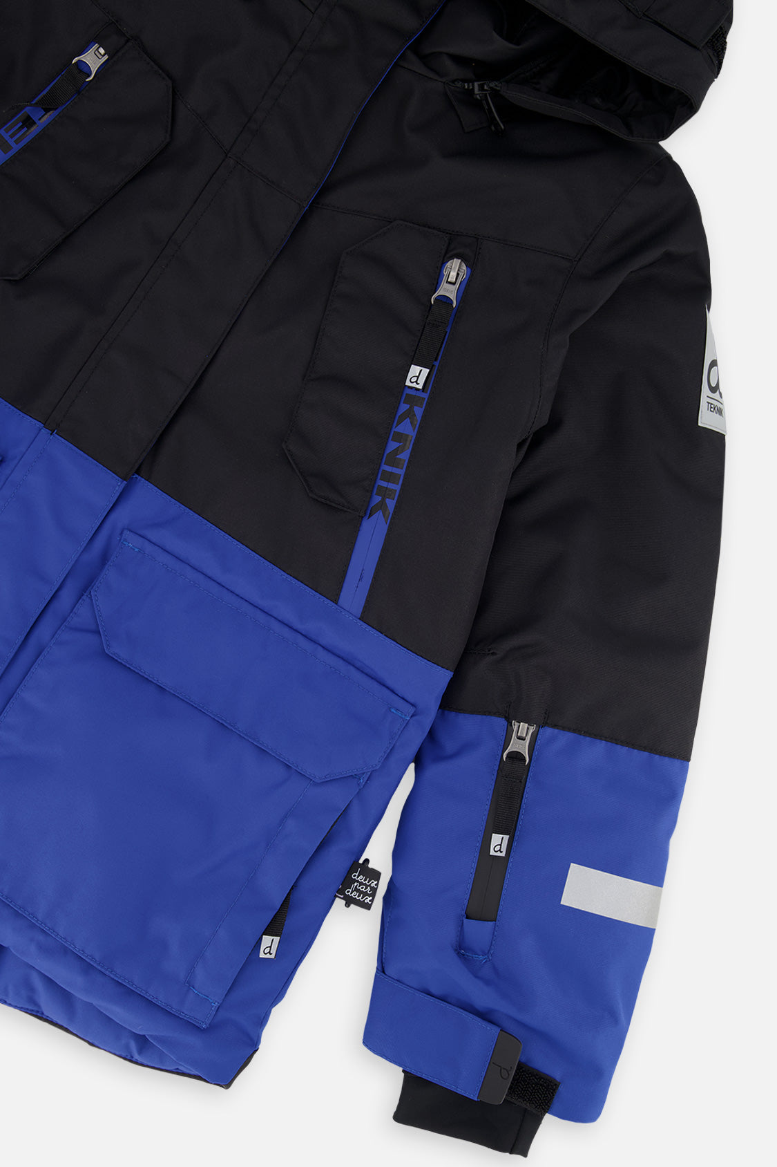 Deux par Deux boys' Teknik two-piece snowsuit in black and royal blue – jacket detail close-up