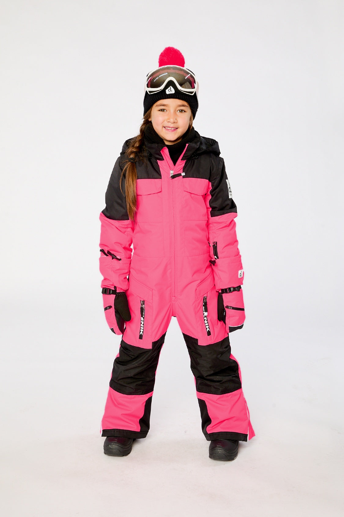 Child wearing the Deux par Deux kids TEKNIK one-piece snowsuit in Bright Pink in a winter lookbook view