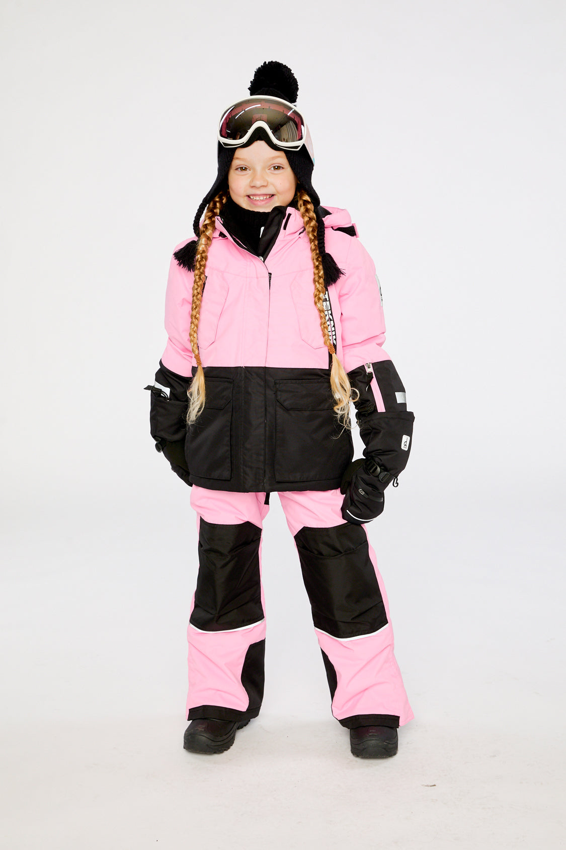 Child wearing the pink Deux par Deux TEKNIK jacket and snow pants in a winter lookbook view