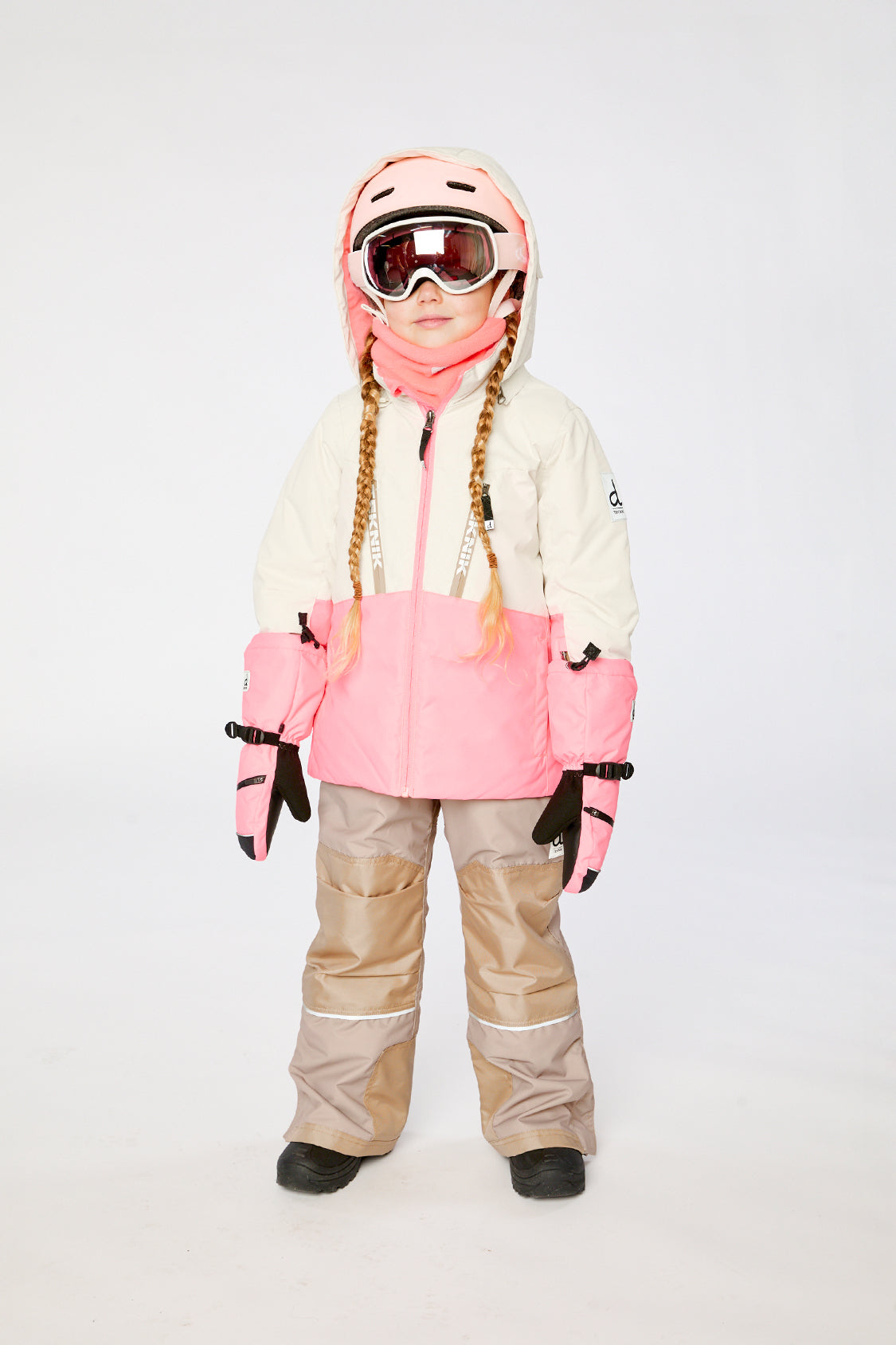 Child wearing the Deux par Deux TEKNIK two-piece snowsuit in Off-White and Pink in a winter lookbook view