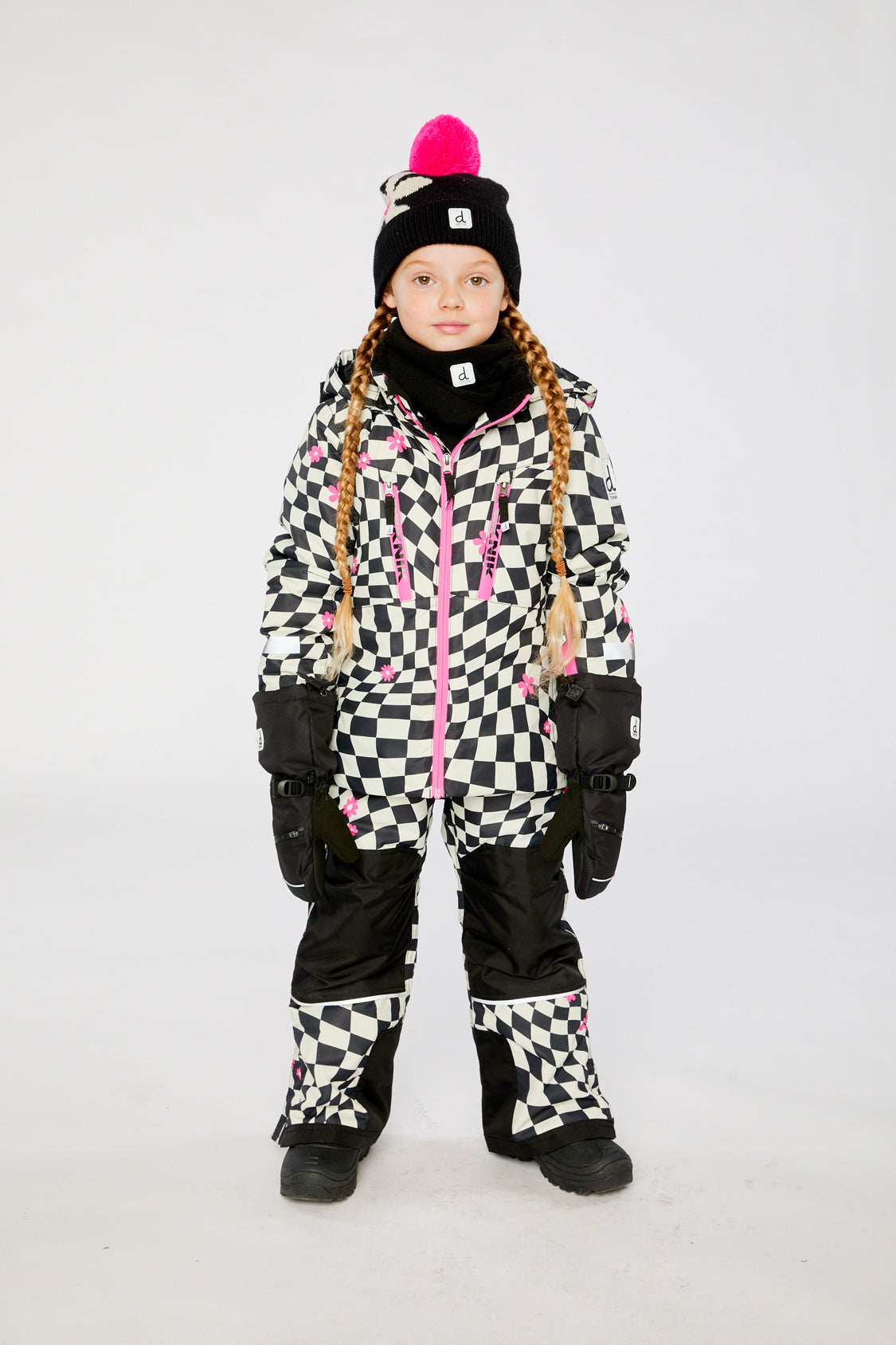 Child wearing the Deux par Deux TEKNIK two-piece snowsuit in White and Bright Pink Checkered Print in a winter lookbook view