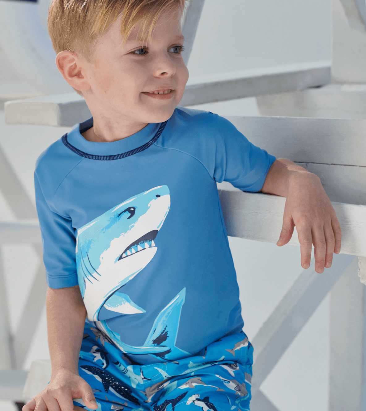 Boy wearing Hatley Deep Sea Shark rashguard with matching swim trunks