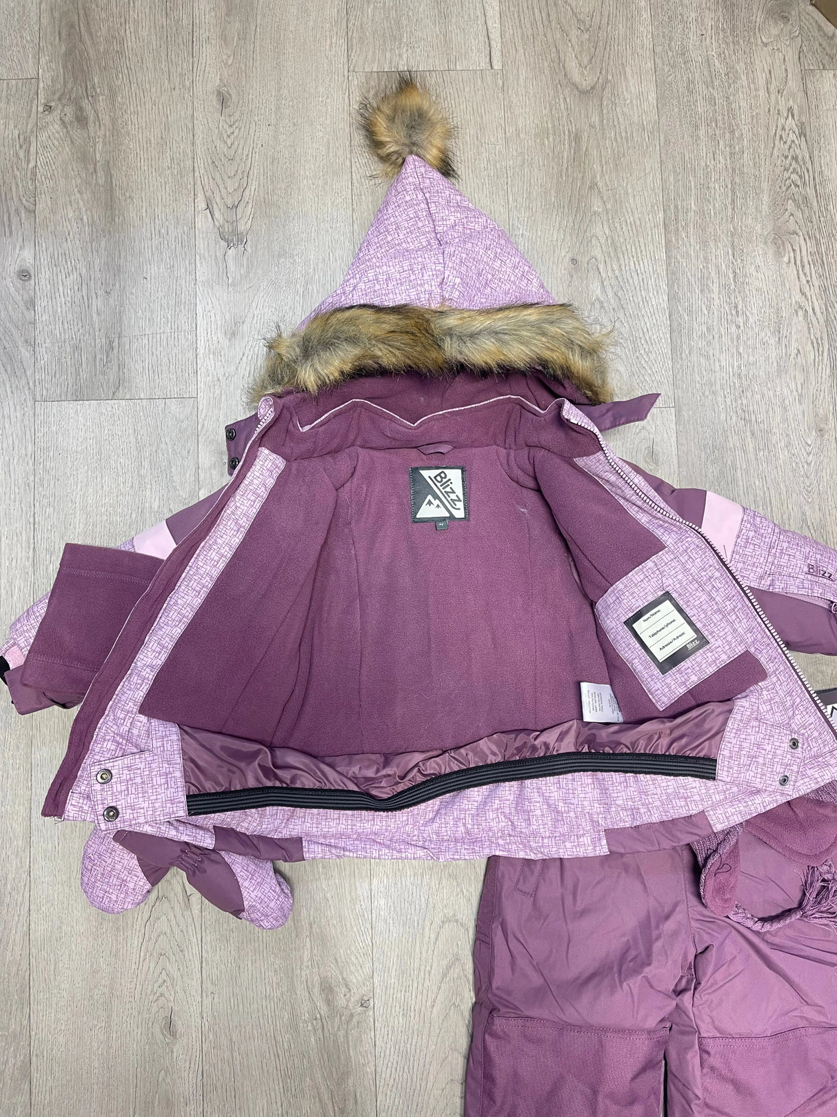 Open view of Blizz girls Lavender snowsuit jacket showing inner lining, snow skirt, and winter construction.