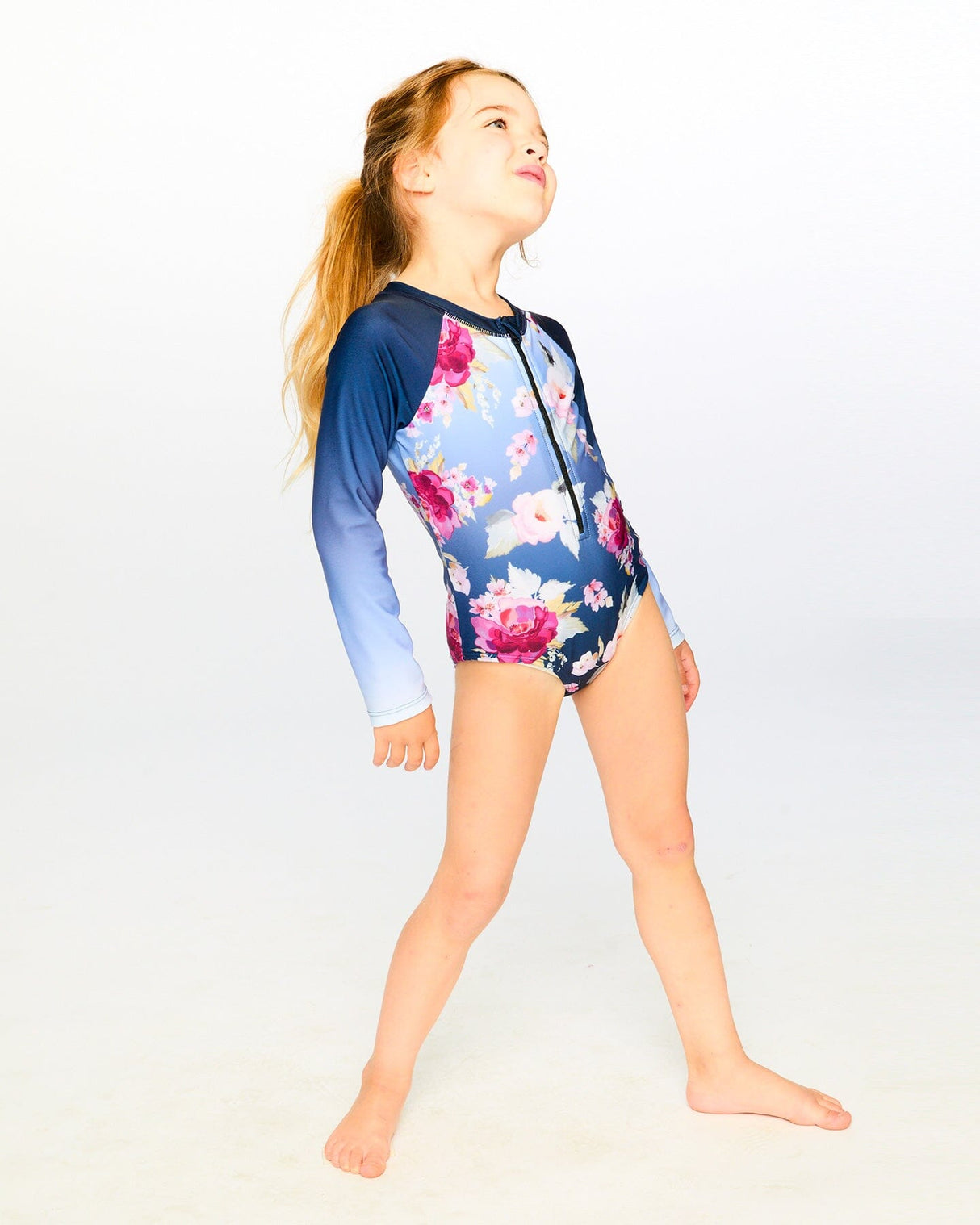 Girl standing in studio wearing Blue Rose rashguard swimsuit front view
