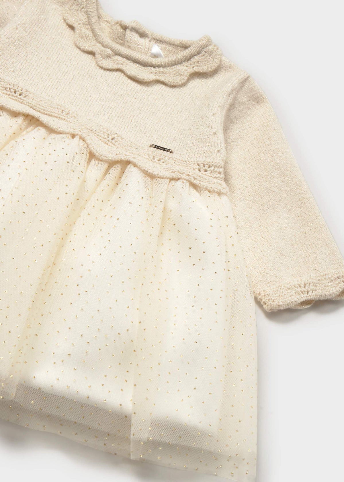 Close view of scalloped collar and gold-dot tulle on ivory Mayoral baby dress