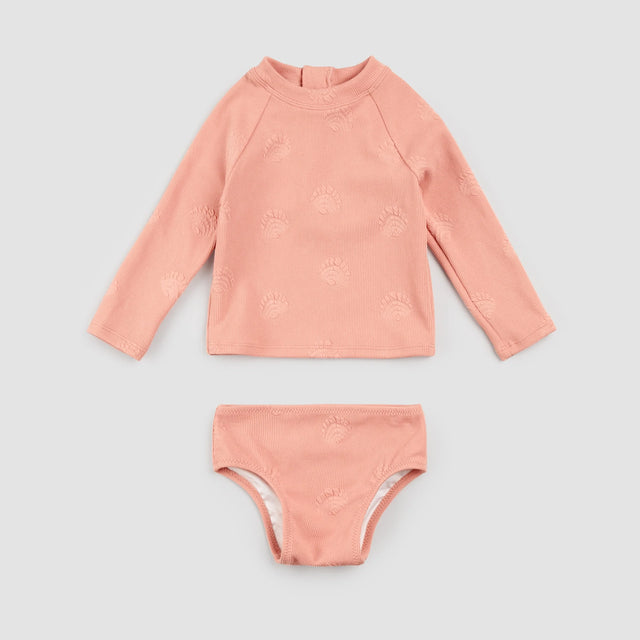 Flat lay of Petit Lem ribbed coral two-piece swimsuit rashguard set with embossed seashell texture for baby girl and girl