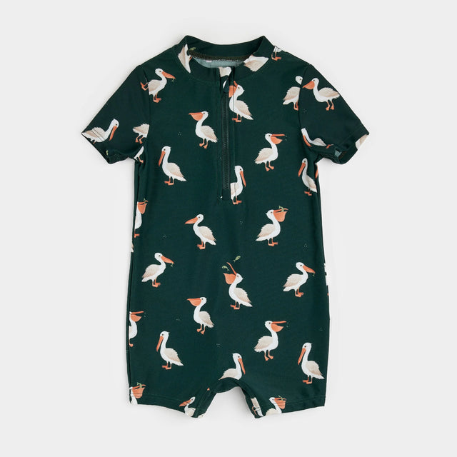 Deep sky pelican-print baby swim romper laid flat showing short sleeves and zipper front.