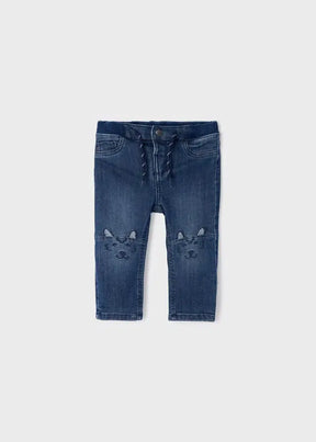 Front view of blue Mayoral baby boy skinny jeans with bear-face knee embroidery