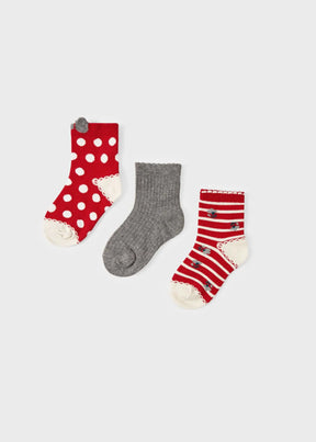 Three Mayoral baby socks in red polka dots, solid grey and red stripes on a light background