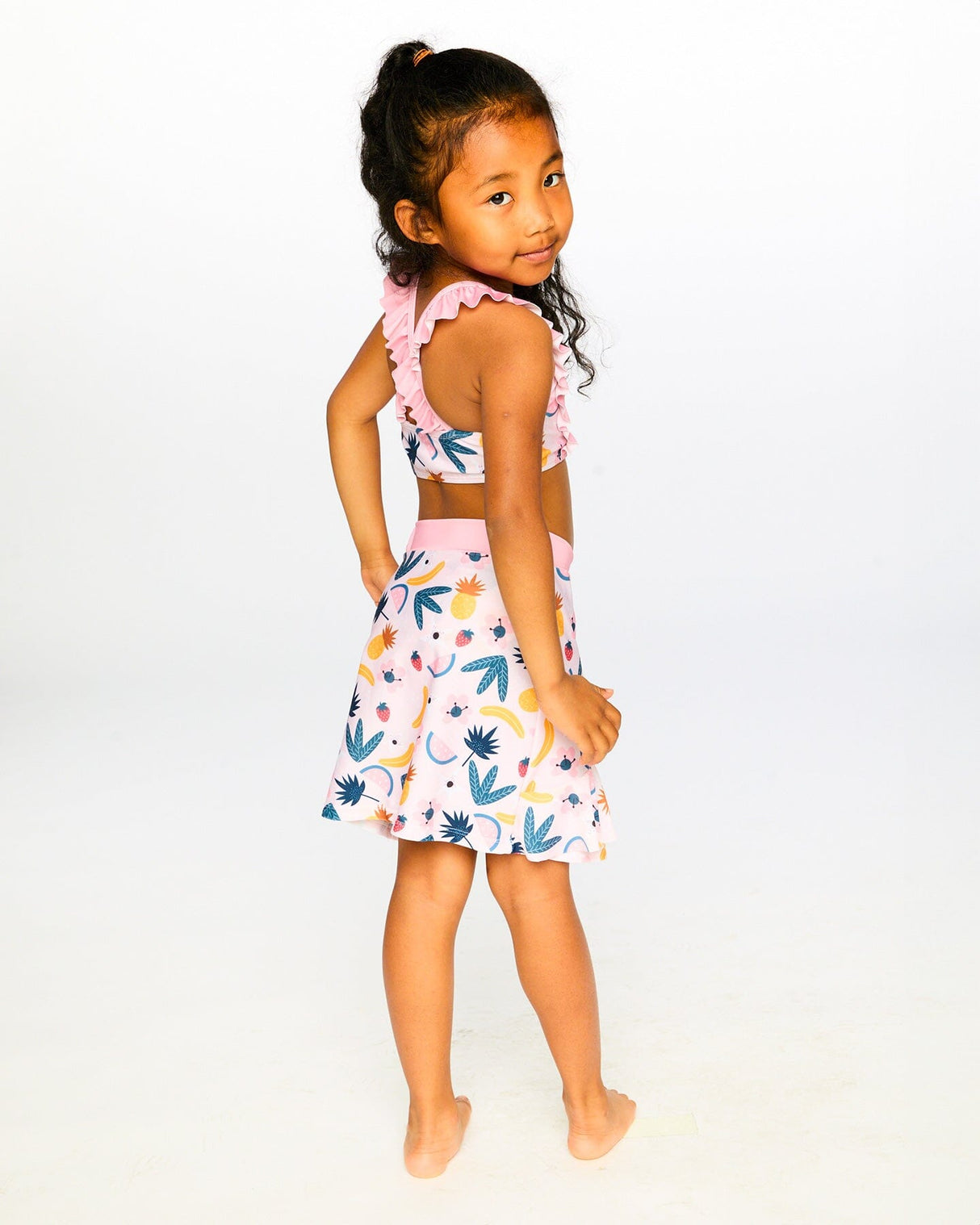 Studio front view of girl wearing pink printed fruits beach skirt cover-up