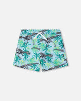 Front flat lay of Deux par Deux boy boardshorts in blue dinosaur skeleton and palm print