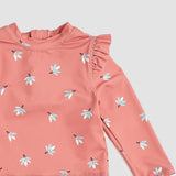 Closeup of Miles The Label girls floral rashguard swimsuit showing Deep Pink fabric, frilly trim, and stretch material.