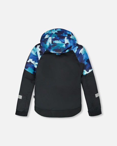 Back view of jacket and snow pants set with detachable hood and snow skirt, teal/blue camo.