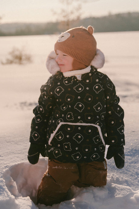 Baby wearing the Deux par Deux baby two-piece snowsuit in Blue Printed Teddy Bears during outdoor winter play
