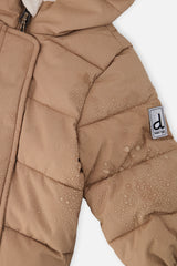 Close-up of the beige quilted sleeve with Deux par Deux logo patch
