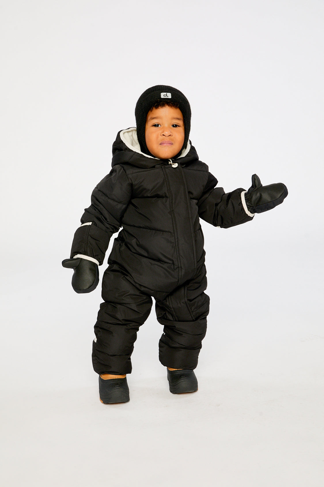 Baby boy wearing Deux par Deux Black Baby Cloud snowsuit with fleece-lined hood