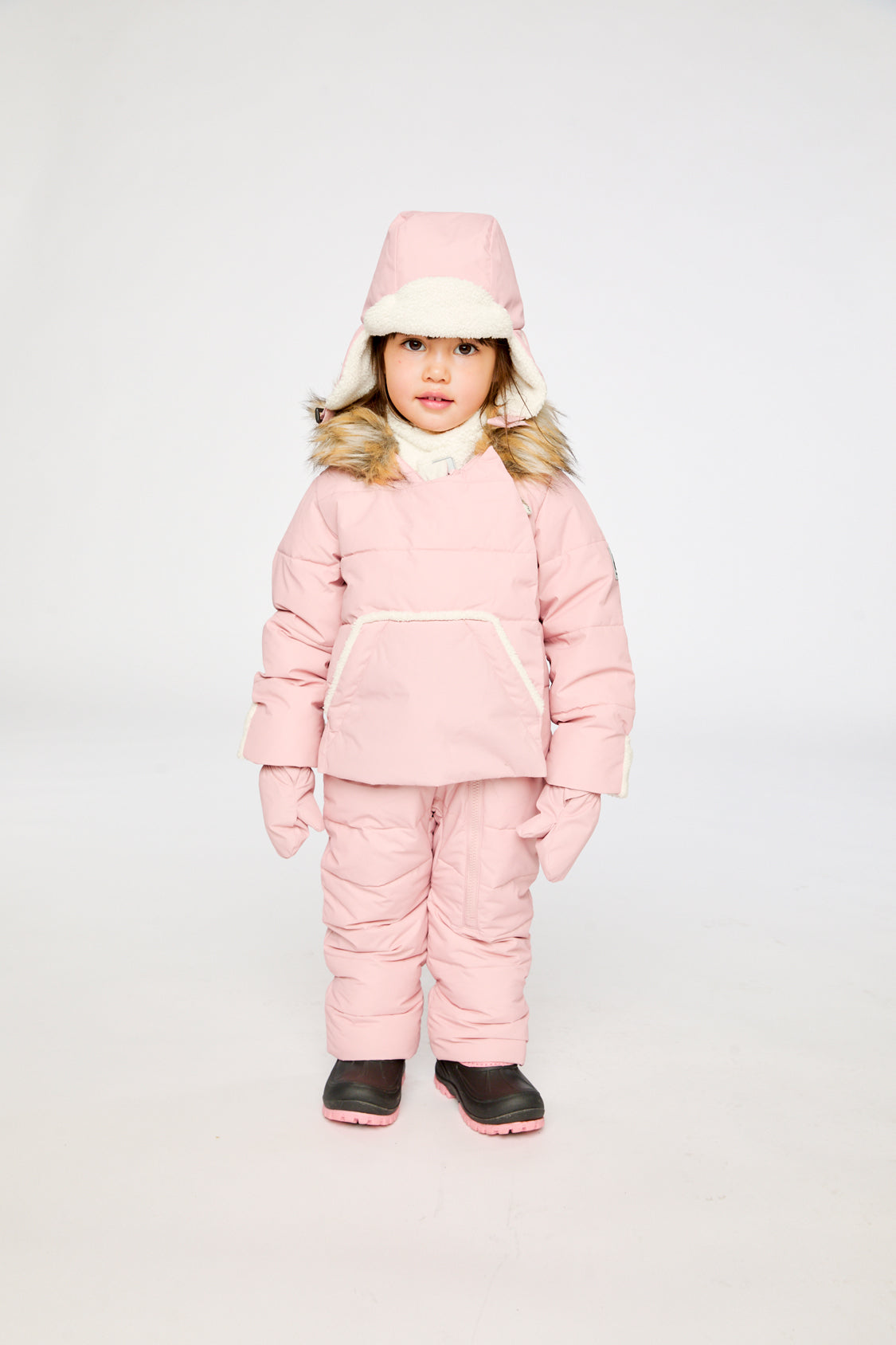 Baby girl wearing Deux par Deux Pale Dusty Pink Baby Snug snowsuit with faux fur hood