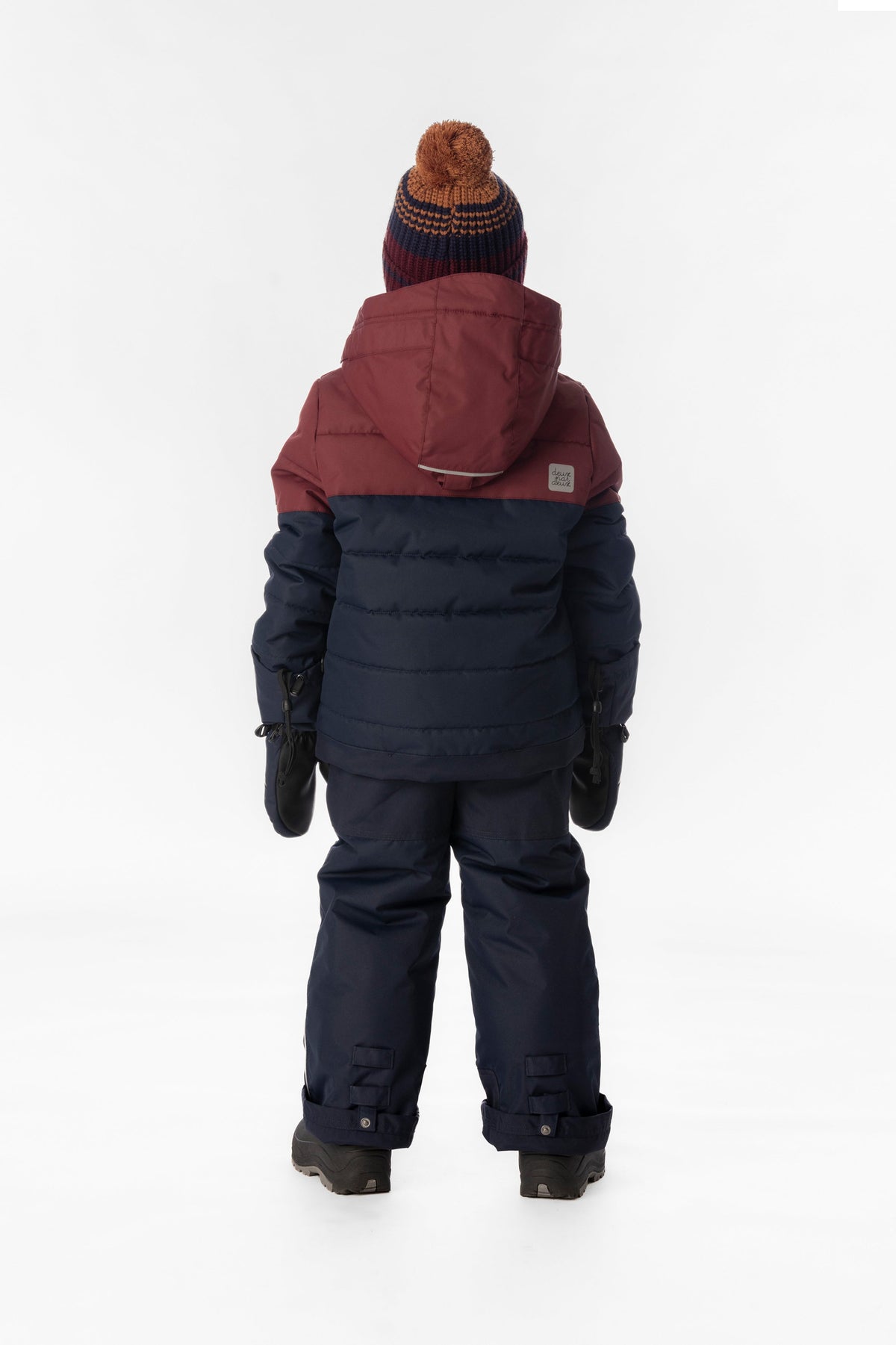 Boy in the navy and burgundy Deux par Deux PLAY snowsuit, back view