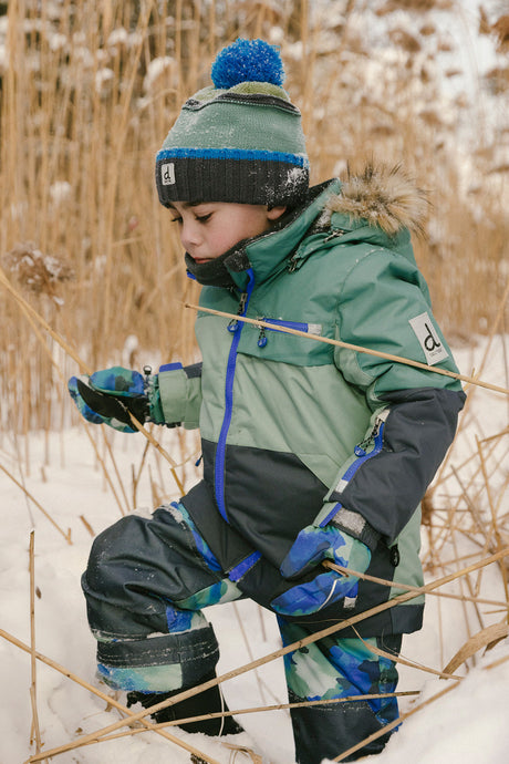 Boy in Deux par Deux -30°C green navy snowsuit for skiing sledding and snow play