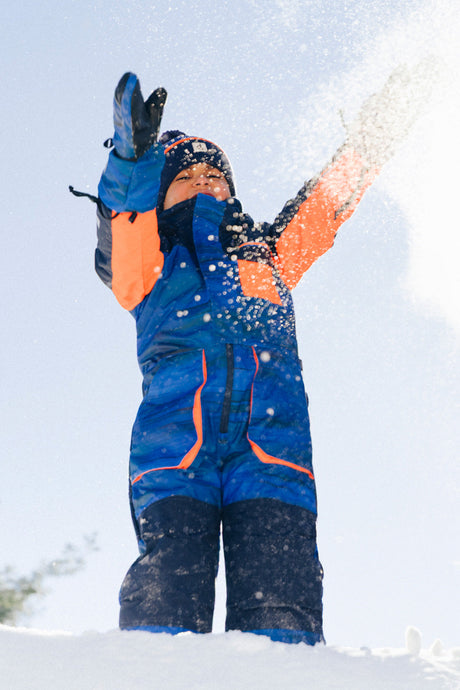 Deux par Deux blue black striped PLAY one-piece snowsuit shown in a second winter lifestyle view