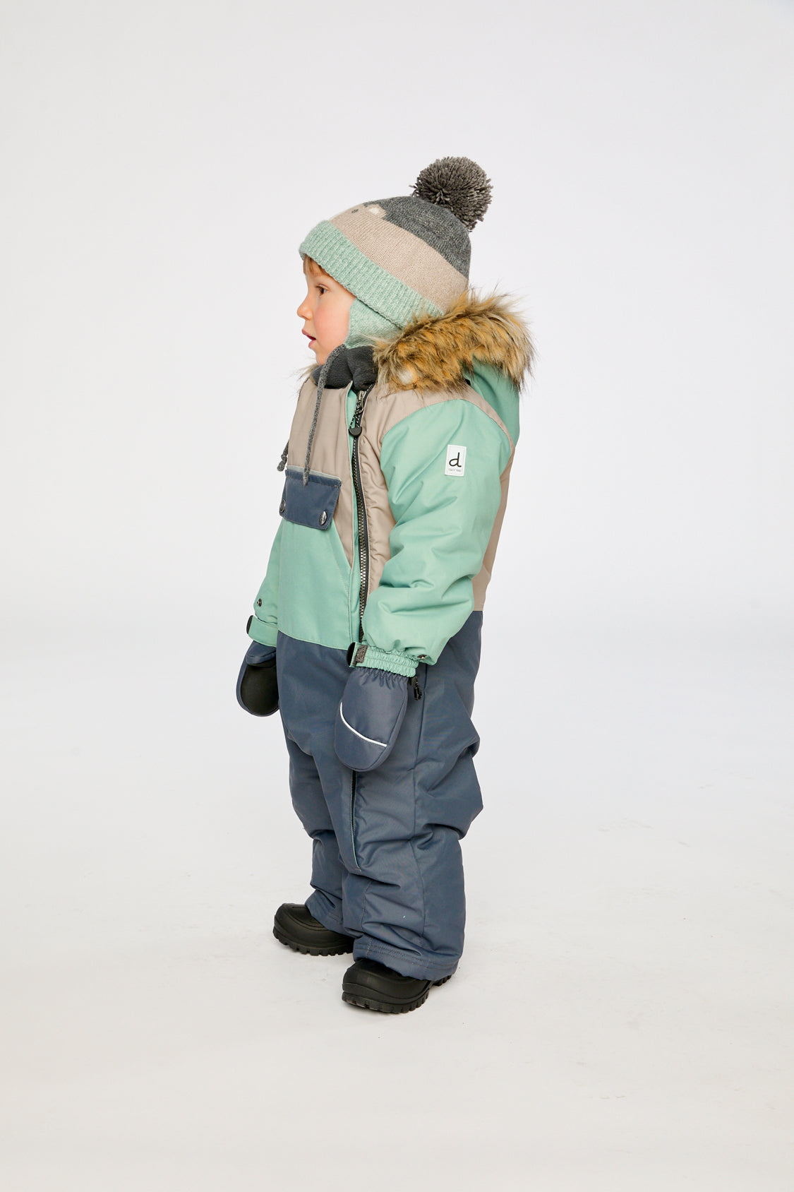 Deux par Deux baby car-seat one-piece snowsuit in Cool Dark Grey shown from an alternate modeled winter angle