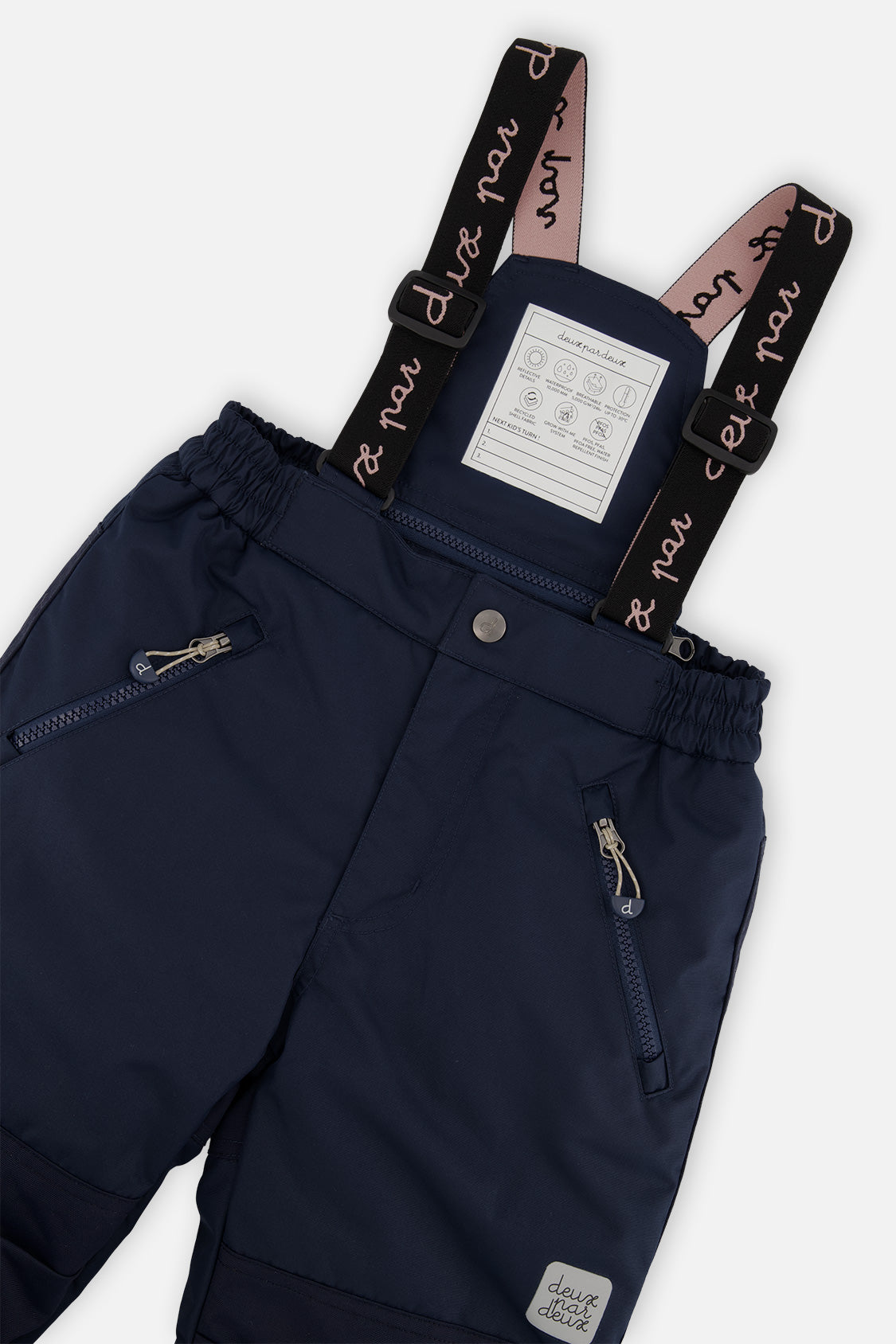 Close-up of the navy snow pants waist, zip pockets and Deux par Deux suspenders