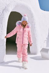 Girl walking out of a snow igloo in the light pink Deux par Deux PLAY snowsuit